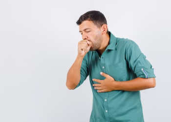 Young man suffering from cough in shirt and looking ill. front view.