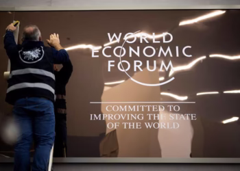 epaselect epa12658057 A worker sets up a logo in the Congress Centre prior the 56th annual meeting of the World Economic Forum (WEF), in Davos, Switzerland, 18 January 2026. The World Economic Forum annual meeting takes place in Davos from 19 to 23 January 2026.  EPA/GIAN EHRENZELLER